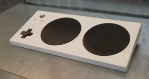 White, large plastic controller with two joysticks and a directional pad